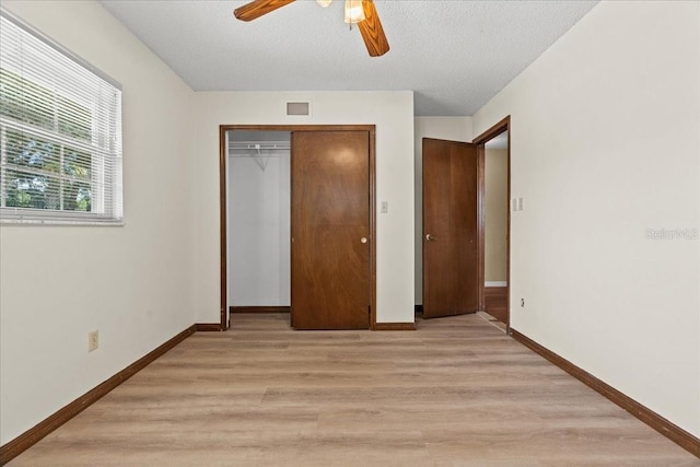 3942 Orange Lake Dr, Orlando, FL 32817 - unfurnished bedroom featuring light wood-style flooring, baseboards, a closet, ceiling fan, and a textured ceiling