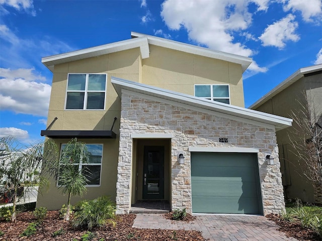 949 Leader St, Davenport, FL 33896 - contemporary home with stone siding, stucco siding, driveway, and an attached garage