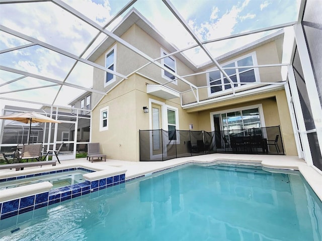 949 Leader St, Davenport, FL 33896 - back of house with stucco siding, a patio area, glass enclosure, and a pool with connected hot tub