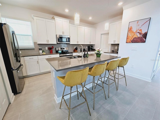 949 Leader St, Davenport, FL 33896 - kitchen with appliances with stainless steel finishes, a sink, backsplash, a breakfast bar area, and recessed lighting