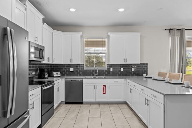 8822 Interlocking Ct, Davenport, FL 33896 - kitchen with stainless steel appliances, a sink, a peninsula, healthy amount of natural light, and recessed lighting