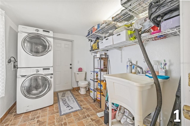 10227 Parsons St, Tampa, FL 33615 - laundry room featuring stacked washing machine and dryer, brick patterned flooring, and baseboards