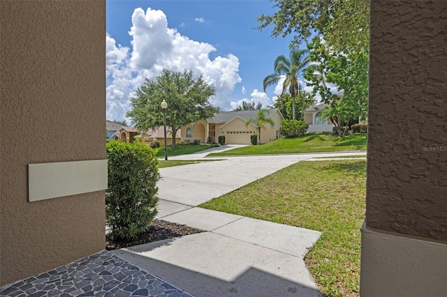 12824 Cloverdale Ln, Clermont, FL 34711 - view of green lawn featuring concrete driveway, an attached garage, and a residential view
