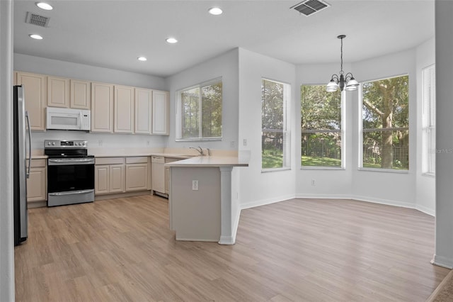 12824 Cloverdale Ln, Clermont, FL 34711 - kitchen featuring appliances with stainless steel finishes, a peninsula, light wood finished floors, light countertops, and recessed lighting