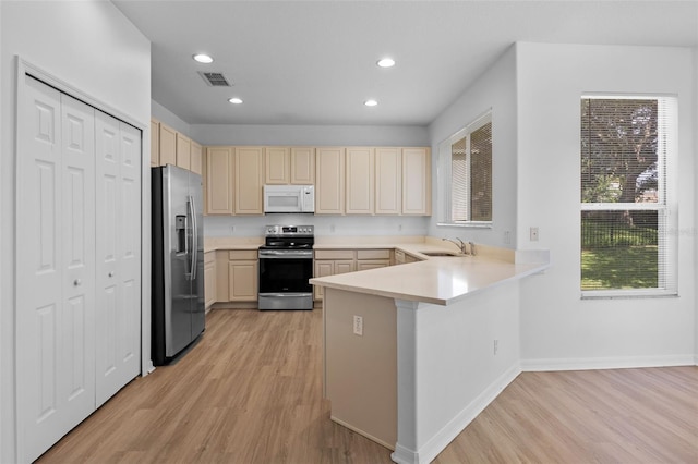 12824 Cloverdale Ln, Clermont, FL 34711 - kitchen with appliances with stainless steel finishes, light wood finished floors, a peninsula, light countertops, and recessed lighting
