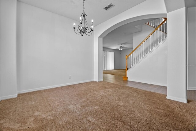 12824 Cloverdale Ln, Clermont, FL 34711 - unfurnished living room with carpet floors, arched walkways, stairway, a chandelier, and ceiling fan