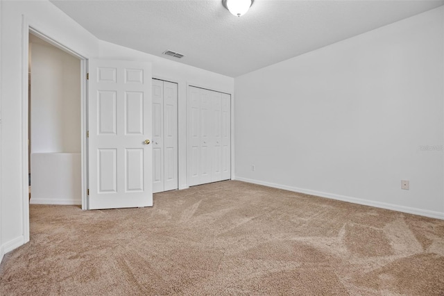 12824 Cloverdale Ln, Clermont, FL 34711 - unfurnished bedroom featuring carpet floors and two closets
