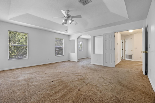 12824 Cloverdale Ln, Clermont, FL 34711 - carpeted empty room with a tray ceiling, ceiling fan, and arched walkways