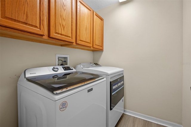 12824 Cloverdale Ln, Clermont, FL 34711 - laundry area with cabinet space, separate washer and dryer, and light wood finished floors