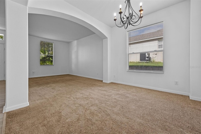 12824 Cloverdale Ln, Clermont, FL 34711 - spare room with a chandelier, arched walkways, and carpet floors