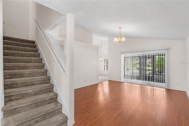 9145 Fort Jefferson Blvd, Orlando, FL 32822 - stairs with a chandelier, lofted ceiling, wood finished floors, a textured ceiling, and baseboards