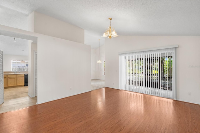 9145 Fort Jefferson Blvd, Orlando, FL 32822 - unfurnished living room featuring a chandelier, vaulted ceiling, light wood-type flooring, a textured ceiling, and a sink
