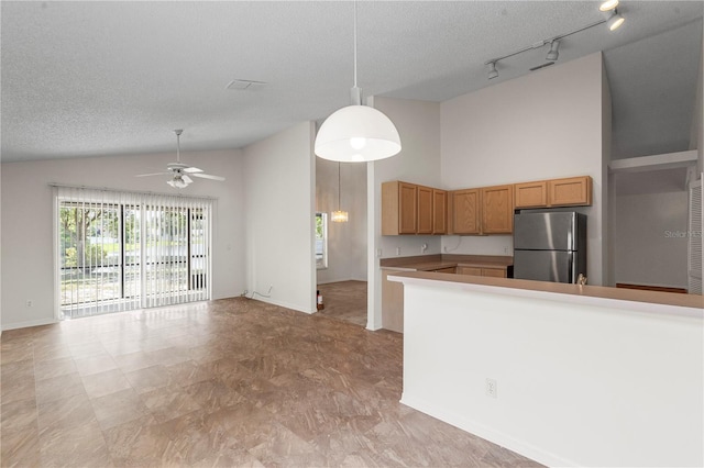 9145 Fort Jefferson Blvd, Orlando, FL 32822 - kitchen with freestanding refrigerator, rail lighting, a ceiling fan, open floor plan, and a textured ceiling