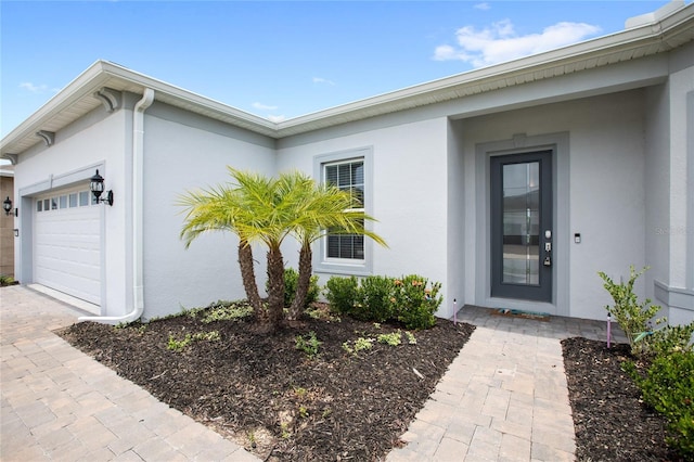 15049 Canopy Cover Dr, Winter Garden, FL 34787 - view of exterior entry featuring stucco siding and an attached garage