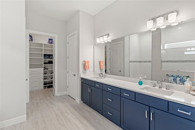 15049 Canopy Cover Dr, Winter Garden, FL 34787 - full bath featuring double vanity, tiled shower, a walk in closet, wood finished floors, and baseboards