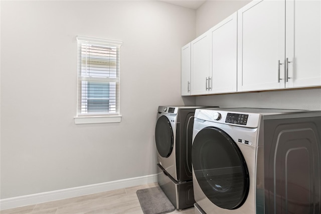 15049 Canopy Cover Dr, Winter Garden, FL 34787 - laundry area with washer and clothes dryer, cabinet space, baseboards, and light wood-type flooring