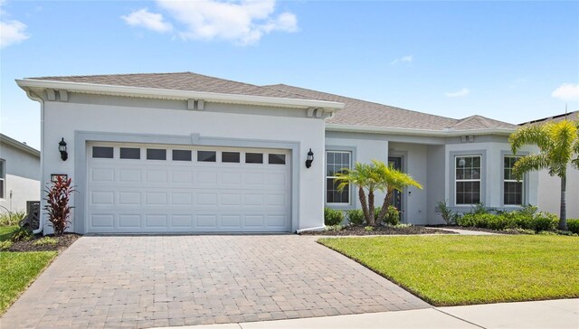 15049 Canopy Cover Dr, Winter Garden, FL 34787 - single story home featuring decorative driveway, stucco siding, a front yard, and a garage