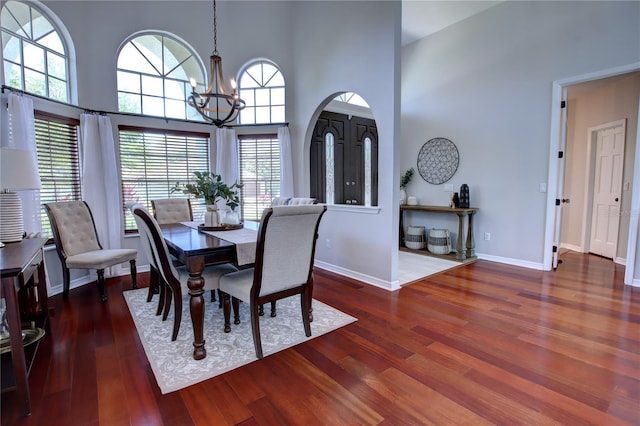 1676 Bear Crossing Cir, Apopka, FL 32703 - dining area featuring a chandelier, wood finished floors, a high ceiling, and baseboards