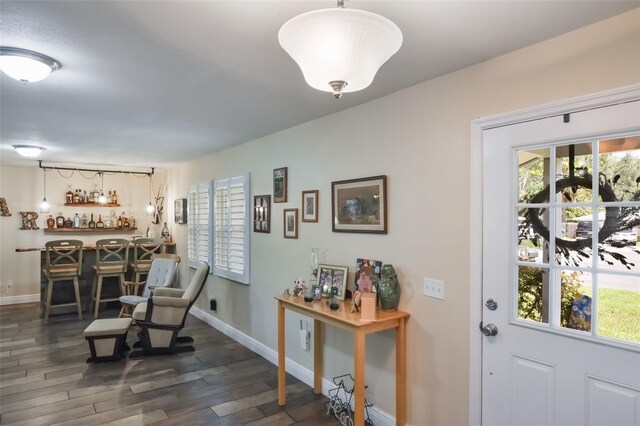 704 Tangerine Ct, Winter Garden, FL 34787 - sitting room featuring a dry bar, wood finished floors, baseboards, and healthy amount of natural light