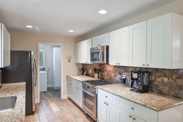 704 Tangerine Ct, Winter Garden, FL 34787 - kitchen with appliances with stainless steel finishes, tasteful backsplash, recessed lighting, light wood finished floors, and washer / dryer