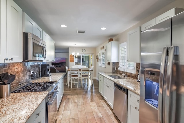 704 Tangerine Ct, Winter Garden, FL 34787 - kitchen with stainless steel appliances, a sink, decorative backsplash, light stone counters, and recessed lighting