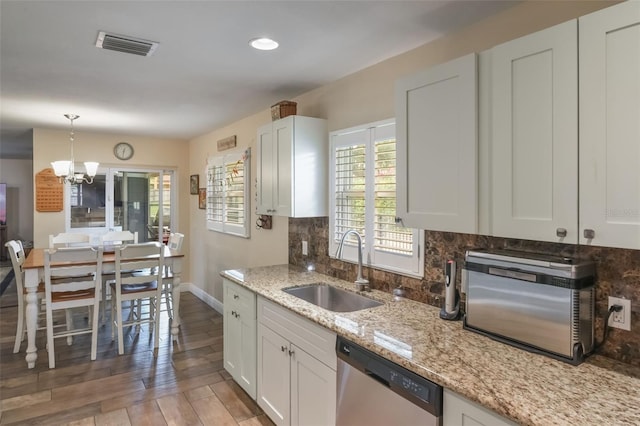 704 Tangerine Ct, Winter Garden, FL 34787 - kitchen featuring dishwasher, a sink, a chandelier, and white cabinetry