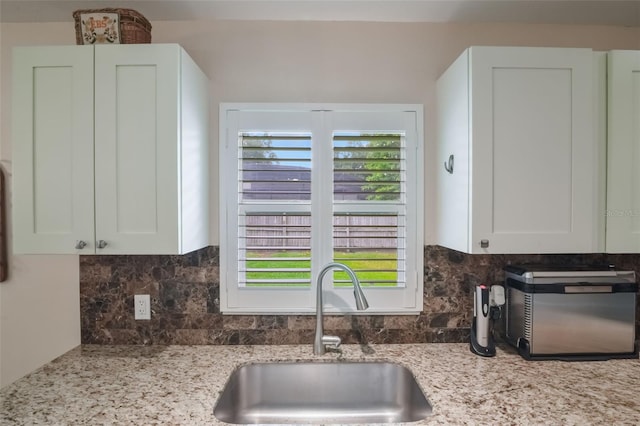 704 Tangerine Ct, Winter Garden, FL 34787 - kitchen featuring a sink, tasteful backsplash, and white cabinetry