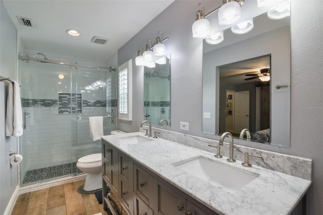 704 Tangerine Ct, Winter Garden, FL 34787 - full bathroom featuring double vanity, a stall shower, toilet, ceiling fan, and wood finished floors