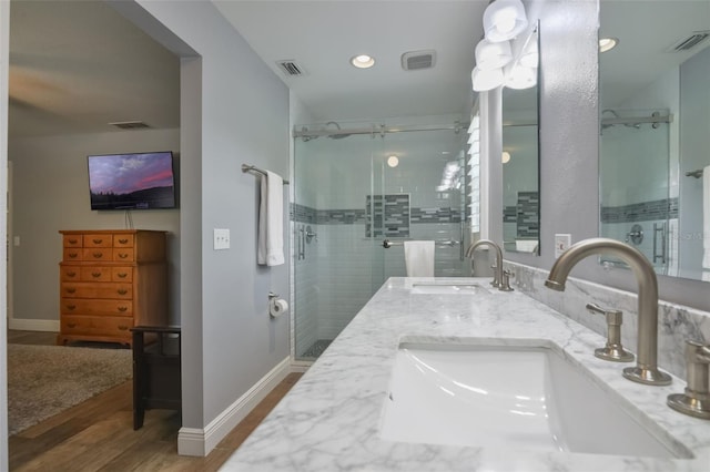 704 Tangerine Ct, Winter Garden, FL 34787 - bathroom featuring a stall shower, wood finished floors, double vanity, baseboards, and recessed lighting