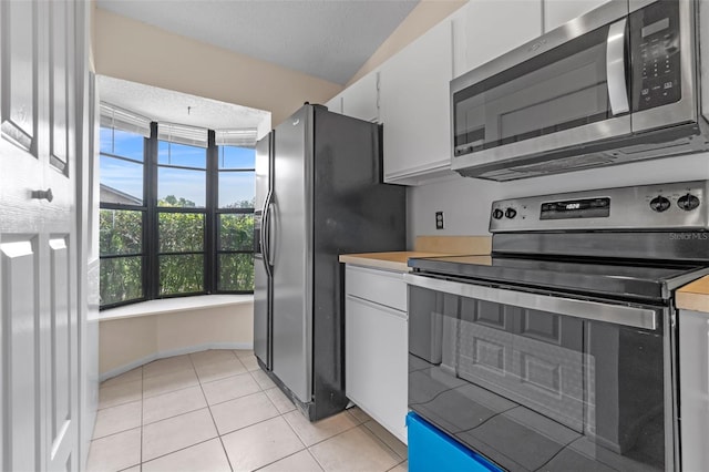 2750 King Oak Cir, Saint Cloud, FL 34769 - kitchen with stainless steel appliances, white cabinetry, light countertops, and light tile patterned floors