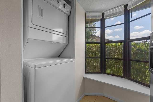 2750 King Oak Cir, Saint Cloud, FL 34769 - laundry room featuring stacked washing machine and dryer, light tile patterned floors, and a textured ceiling