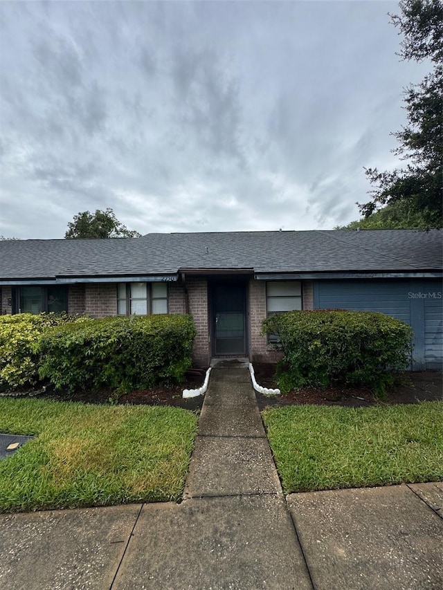 2750 King Oak Cir, Saint Cloud, FL 34769 - single story home featuring brick siding, a shingled roof, and a front lawn