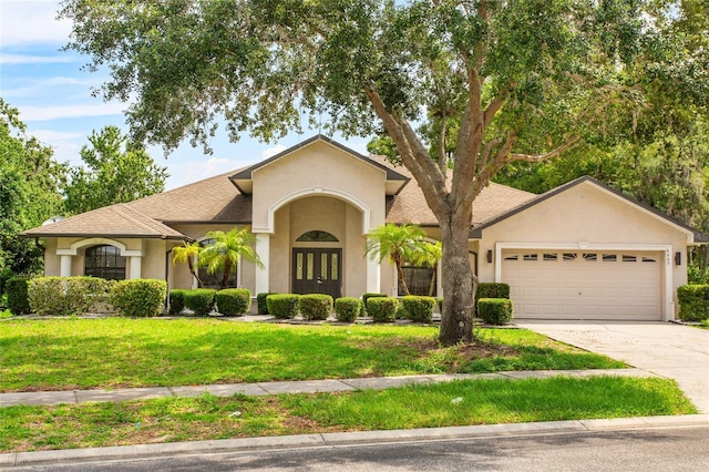 4905 Emilee Grace Ln, Saint Cloud, FL 34771 - view of front of home with french doors, stucco siding, an attached garage, and driveway