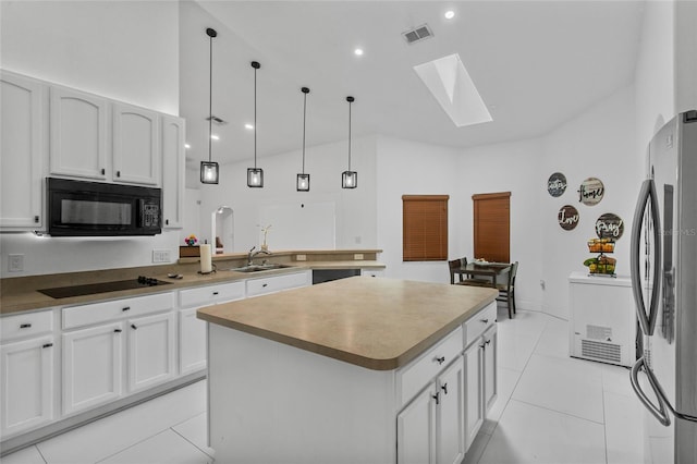 4905 Emilee Grace Ln, Saint Cloud, FL 34771 - kitchen featuring black appliances, a skylight, a sink, lofted ceiling, and a center island