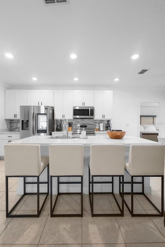 15356 White Tail Loop, Mascotte, FL 34753 - kitchen with appliances with stainless steel finishes, a breakfast bar area, white cabinetry, and recessed lighting
