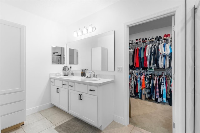 15356 White Tail Loop, Mascotte, FL 34753 - bathroom with double vanity, a spacious closet, tile patterned floors, and baseboards