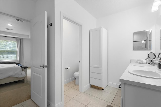15356 White Tail Loop, Mascotte, FL 34753 - bathroom with double vanity, tile patterned floors, toilet, and ensuite bathroom