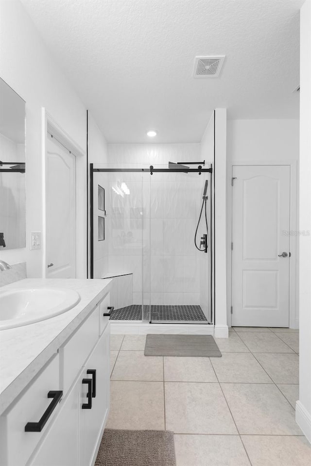15356 White Tail Loop, Mascotte, FL 34753 - bathroom with vanity, a shower stall, tile patterned floors, a textured ceiling, and recessed lighting
