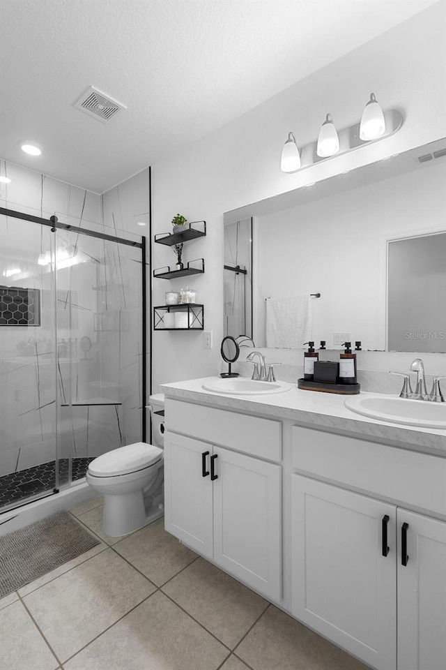 15356 White Tail Loop, Mascotte, FL 34753 - bathroom with double vanity, a stall shower, toilet, and tile patterned flooring