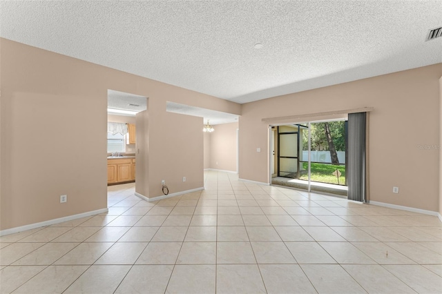 476 Basking Ridge Ct, Ocoee, FL 34761 - empty room featuring a textured ceiling, a chandelier, light tile patterned floors, and baseboards
