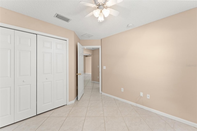476 Basking Ridge Ct, Ocoee, FL 34761 - unfurnished bedroom featuring a textured ceiling, a closet, light tile patterned floors, baseboards, and a ceiling fan