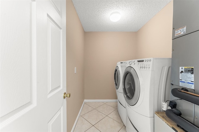 476 Basking Ridge Ct, Ocoee, FL 34761 - laundry area featuring washer and dryer, a textured ceiling, light tile patterned floors, baseboards, and heating unit