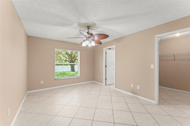 476 Basking Ridge Ct, Ocoee, FL 34761 - unfurnished bedroom featuring a spacious closet, a closet, a textured ceiling, a ceiling fan, and light tile patterned flooring