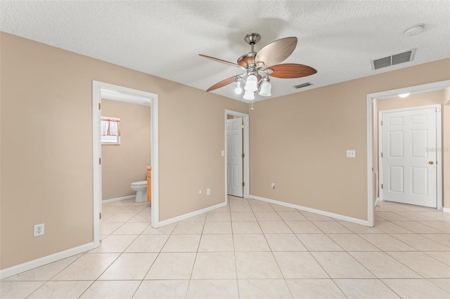 476 Basking Ridge Ct, Ocoee, FL 34761 - unfurnished bedroom with a textured ceiling, baseboards, light tile patterned floors, and ensuite bathroom