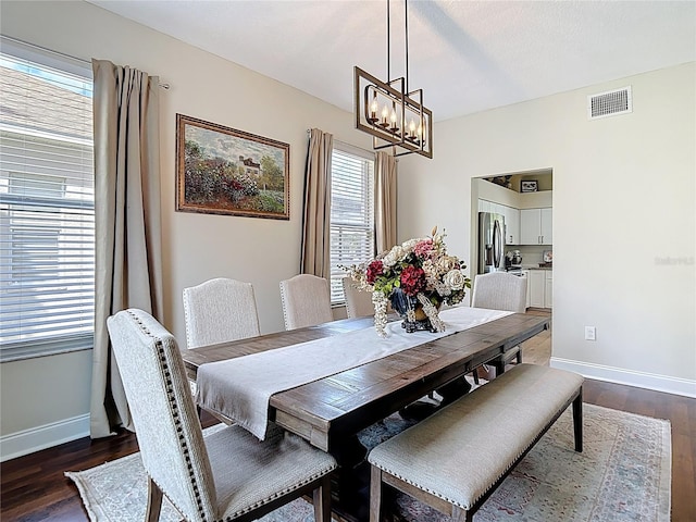 18109 Kara Ct, Tampa, FL 33647 - dining room with healthy amount of natural light, a chandelier, baseboards, and dark wood-type flooring