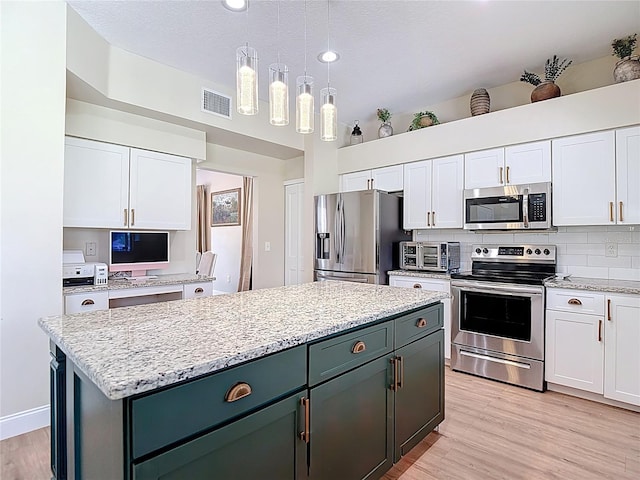 18109 Kara Ct, Tampa, FL 33647 - kitchen featuring appliances with stainless steel finishes, white cabinets, a kitchen island, light wood-type flooring, and recessed lighting