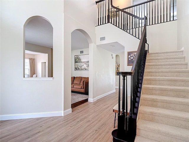 18109 Kara Ct, Tampa, FL 33647 - staircase featuring arched walkways, wood finished floors, baseboards, and a high ceiling