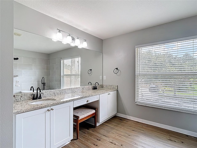 18109 Kara Ct, Tampa, FL 33647 - full bath with double vanity, wood finished floors, baseboards, and a tile shower