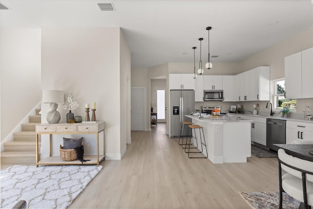811 E Mcdonald Ave, Eustis, FL 32726 - kitchen with stainless steel appliances, a kitchen bar, light wood-type flooring, and a center island