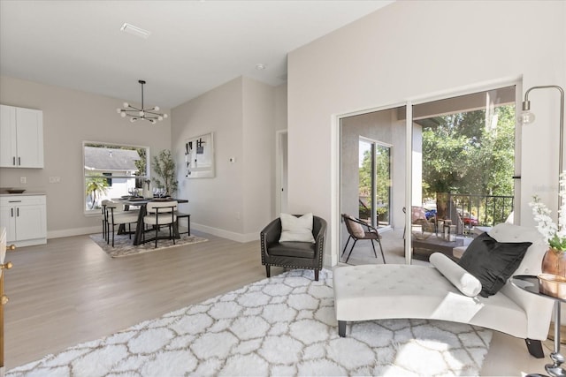 811 E Mcdonald Ave, Eustis, FL 32726 - living room featuring light wood-style floors, a chandelier, plenty of natural light, and baseboards